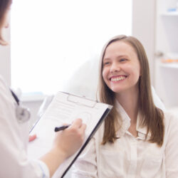 teen patient smiling at her gynecologist and benefiting from continuity of care | University of Colorado OB-GYN | CO