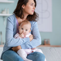 A woman holding her baby thinking about lochia | CU OB-GYN | Denver & Aurora, CO