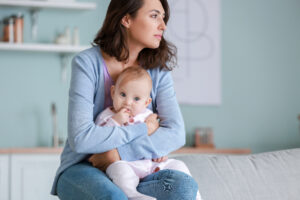 A woman holding her baby thinking about lochia | CU OB-GYN | Denver & Aurora, CO