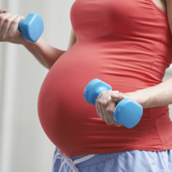 Pregnancy and Exercise | CU OB-GYN | Photo of pregnant woman with weights