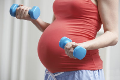 Pregnancy and Exercise | CU OB-GYN | Photo of pregnant woman with weights